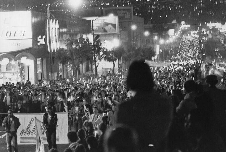 SFO Museum Exhibition; Mourners march down Market Street in a candlelight vigil after the assassination of Mayor George Moscone and Supervisor Harvey Milk November 27, 1978 Photograph by Efren Convento Ramirez (1941–2017) Collection of Efren Ramirez; Courtesy of the GLBT Historical Society OAC 2010-05; R2020.0604.007